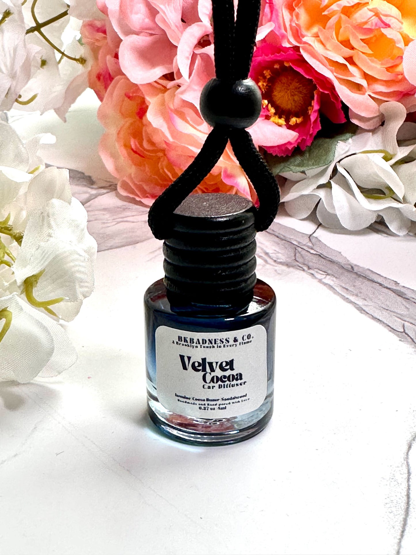 Bottle of 'Velvet Cocoa' perfume with floral background